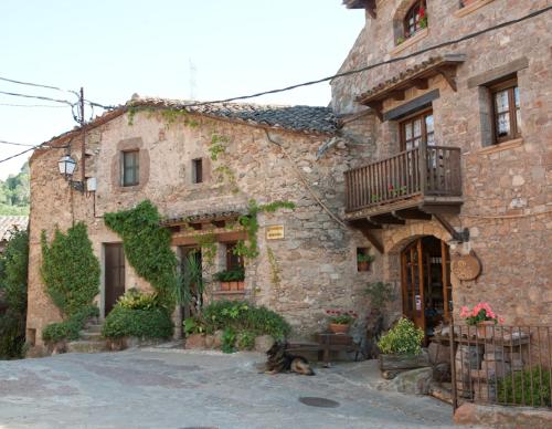 a dog laying in front of a stone building at APARTAMENTS PUIG GILI in Mura