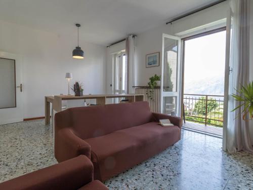 a living room with a couch and a balcony at Mamma Ciccia Holiday Home - Mountains & Lake in Mandello del Lario