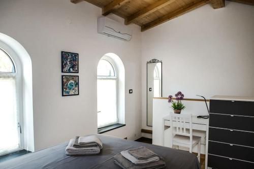 - une chambre avec un lit, un bureau et 2 fenêtres dans l'établissement La CASETTA Antica dimora nel centro storico, à Chiavari