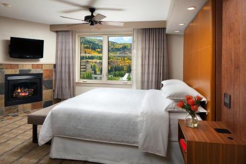 Sheraton Mountain Vista Villas, Avon / Vail Valley في آفون: غرفة نوم بسرير كبير ومدفأة