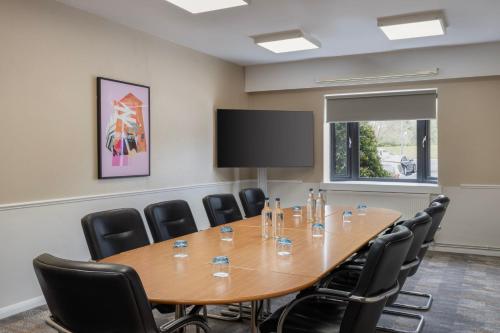 a conference room with a large wooden table and chairs at Delta Hotels by Marriott Northampton in Northampton
