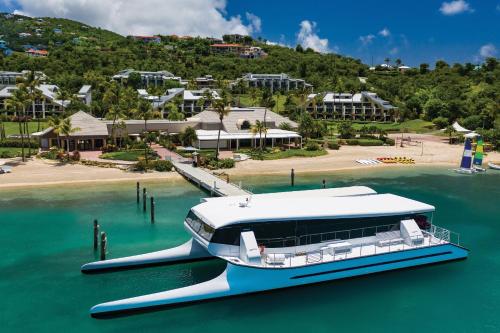 a boat docked in the water next to a resort at The Westin St. John Resort Villas in Saint John