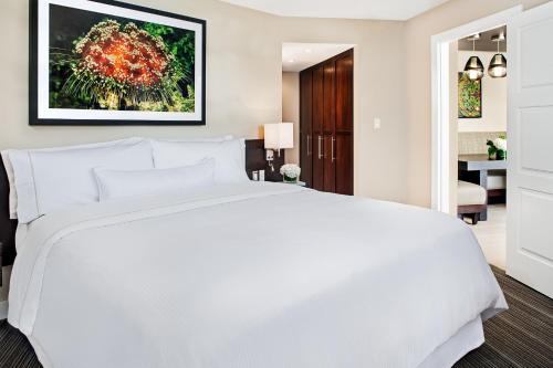 a bedroom with a white bed and a living room at The Westin St. John Resort Villas in Saint John