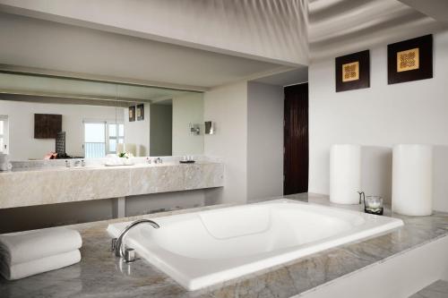 a bathroom with a large tub and a large mirror at The Westin Resort & Spa Cancun in Cancún