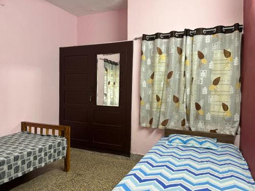 1 dormitorio con puerta, cama y ventana en Sowparnika duplex, en Trivandrum