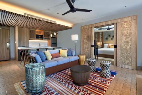 a living room with a blue couch and a kitchen at Marriott's Bali Nusa Dua Terrace in Nusa Dua