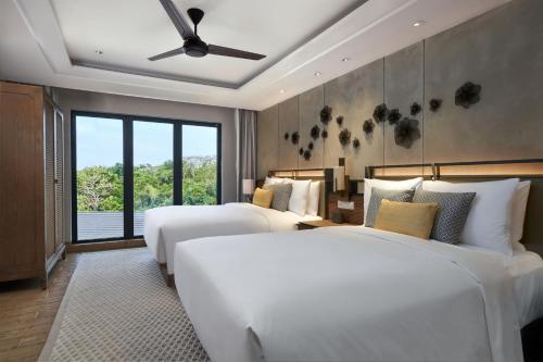 a bedroom with three beds and a ceiling fan at Marriott's Bali Nusa Dua Terrace in Nusa Dua