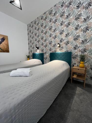 a bedroom with two beds and a wall at Apartments Pia in Subotica