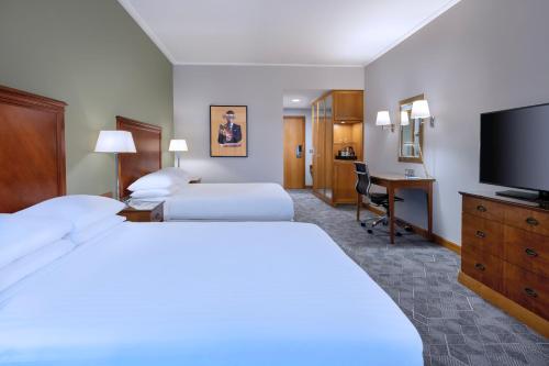 a hotel room with two beds and a flat screen tv at Delta Hotels by Marriott Bexleyheath in Bexleyheath