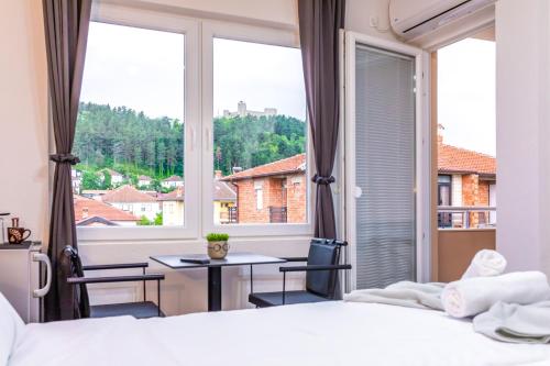 a bedroom with a large window and a table and chairs at Villa Trofej in Ohrid