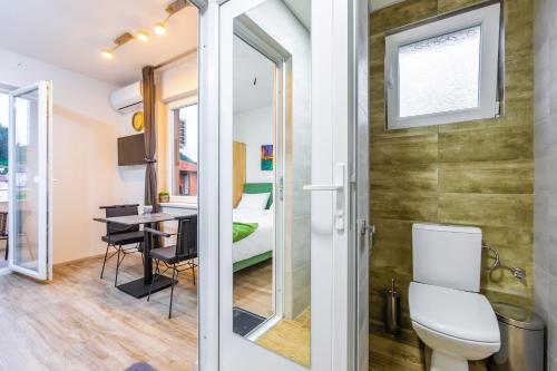a bathroom with a toilet and a room with a desk at Villa Trofej in Ohrid