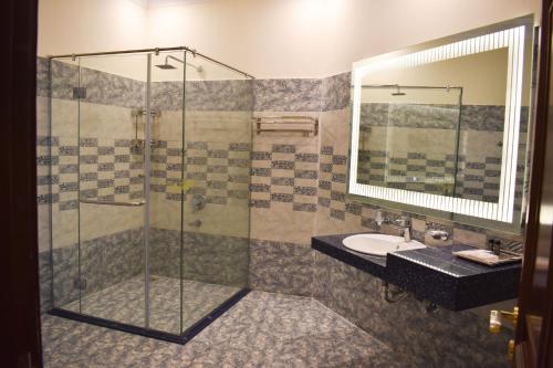 a bathroom with a shower and a sink at Hotel de Raj Sialkot in Sialkot