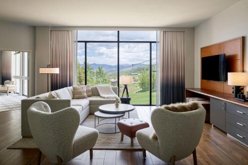 a living room with a couch and chairs and a tv at Viewline Resort Snowmass, Autograph Collection in Snowmass Village