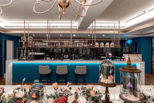 a bar with blue walls and a table with flowers at The Grand Hotel Kaohsiung in Kaohsiung