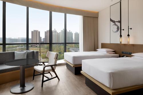 um quarto de hotel com duas camas e uma mesa e um sofá em Fairfield by Marriott Xi'an Chanba em Xian