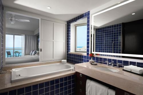 a bathroom with a tub and a sink and a mirror at The Westin Lagunamar Ocean Resort Villas & Spa Cancun in Canc&uacute;n