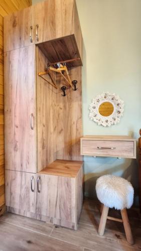 a wooden cabinet with a desk and a stool at Margjelo's Twin Houses in the garden in Shkodër