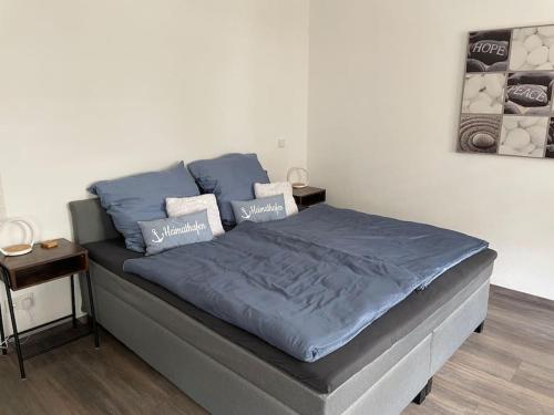 a bed with blue sheets in a room at Ferienwohnung Heistenbach bei Diez/Limburg in Heistenbach
