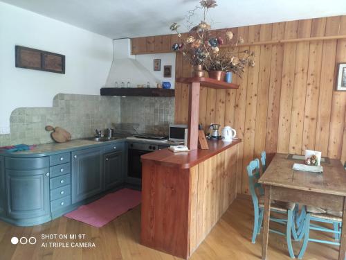 eine Küche mit blauen Schränken und einem Tisch mit einem Tisch in der Unterkunft Appartamento Pila in Pila