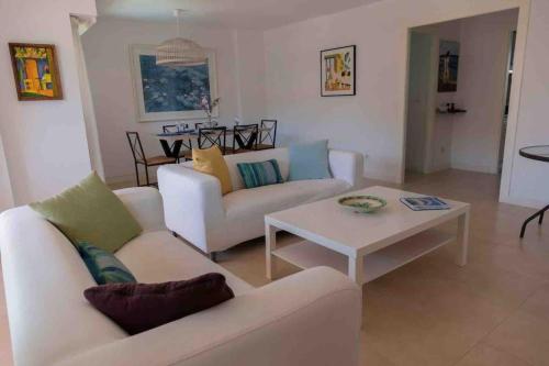 una sala de estar con 2 sofás blancos y una mesa. en Gran apartamento, Aire acondicionado, piscina y parking gratuito, en Alicante