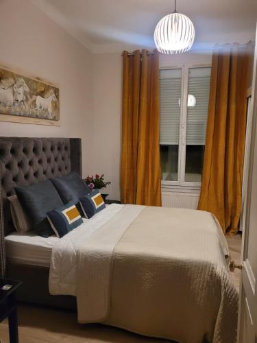 - une chambre avec un grand lit et des rideaux jaunes dans l'établissement Ma maison, mon havre de paix, à Avignon