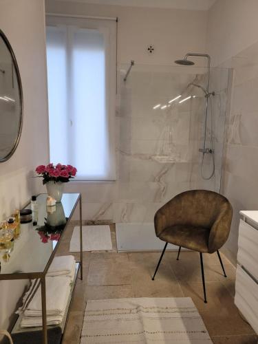 La salle de bains est pourvue d'une douche, d'une chaise et d'une table en verre. dans l'établissement Ma maison, mon havre de paix, à Avignon