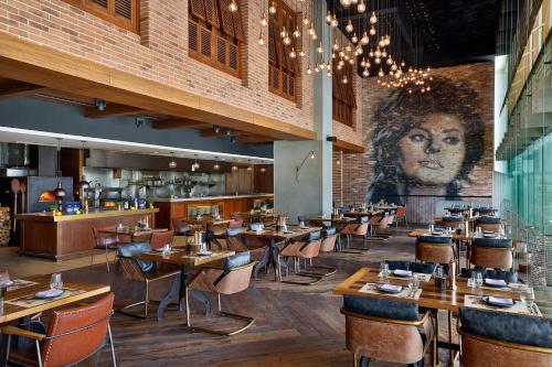 a restaurant with wooden tables and a mural of a woman at The St. Regis Downtown Dubai in Dubai
