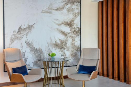 two chairs and a table in a room with a painting at The St. Regis Downtown Dubai in Dubai