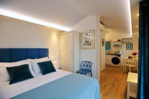 1 dormitorio con 1 cama azul y blanca y cocina en Sunset over the Dubrovnik's Old Town, en Dubrovnik