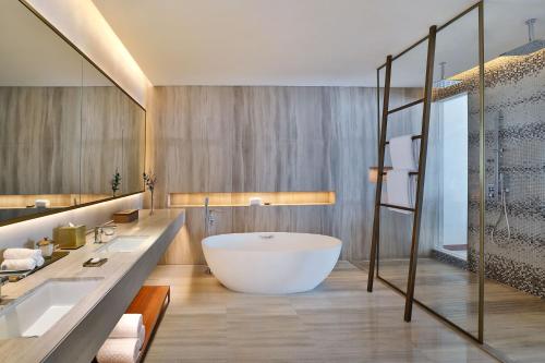 a bathroom with a large tub and a large sink at The St. Regis Downtown Dubai in Dubai
