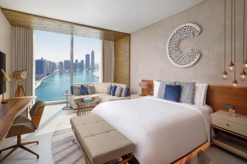 een slaapkamer met een groot bed en een groot raam bij The St. Regis Downtown Dubai in Dubai