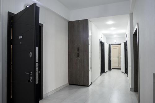 a hallway with black doors and white walls at Apartment on Nizami street in Baku