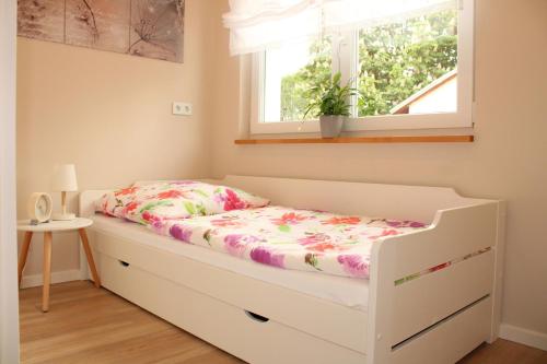 een bed in een kamer met een raam bij Ferienhaus am Mühlteich in Lindenberg