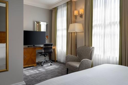 a hotel room with a bed and a desk and chair at Delta Hotels by Marriott Birmingham in Birmingham