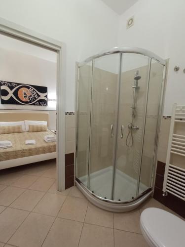 a bathroom with a shower with a toilet and a mirror at Bed & Breakfast Villa Corallo Parcheggio privato in Porto Cesareo