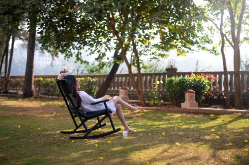 a woman sitting in a chair in the grass at The Westin Mumbai Powai Lake in Mumbai