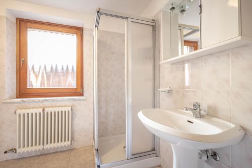 a white bathroom with a sink and a shower at Le Vieux Noyer - Appartamenti al Verde villaggio di Rumiod in Saint-Pierre