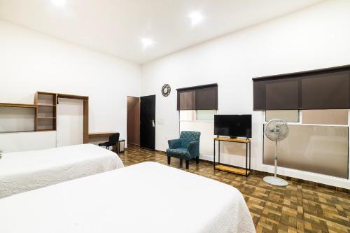 Tlaxcala de XicohténcatlにあるOYO Hotel Boutique Las Campanasのベッド2台、薄型テレビが備わるホテルルームです。