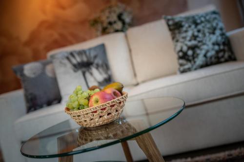 a bowl of fruit on a glass table in front of a couch at Engel 16 in Gutach