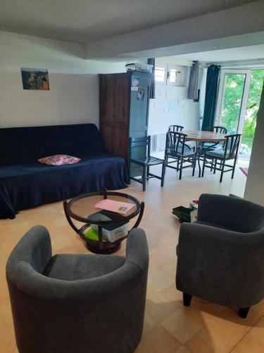 un salon avec un canapé, des chaises et une table dans l'établissement Les coteaux de Planèze, chambre pour 2, 3 ou famille nombreuse 2 adultes 5 enfants et jeunes, à Belmont-Bretenoux