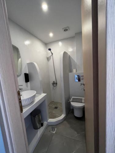a white bathroom with a sink and a toilet at Princess Sissy in Ios Chora