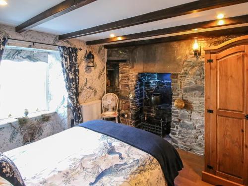 a bedroom with a bed and a stone wall at The Moorings in Garlieston
