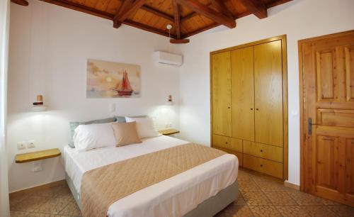 1 dormitorio con 1 cama y armario de madera en PETRINO, en Centro histórico de Alónnisos