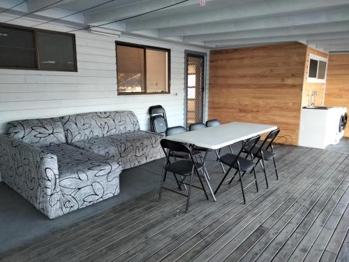 a room with a table and chairs and a couch at Birubi Beach House in Anna Bay