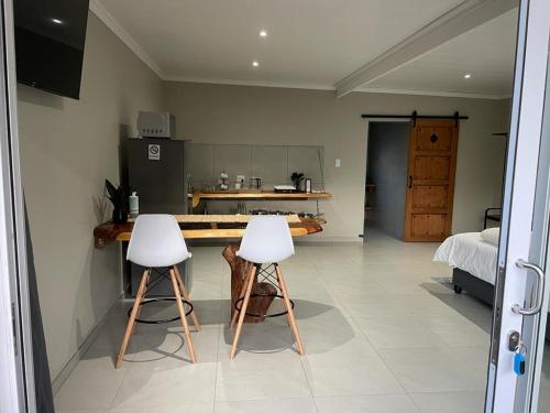 een keuken met twee witte krukken in een kamer bij 30 on Tidewaters in East London