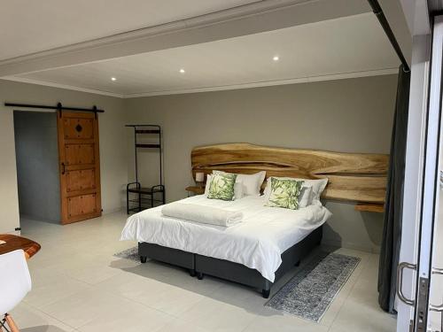 a bedroom with a bed with white sheets and green pillows at 30 on Tidewaters in East London
