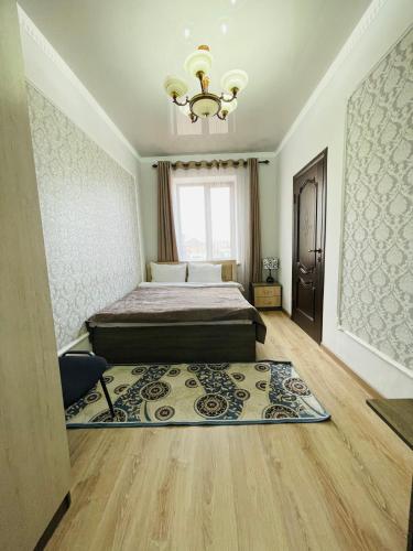 a bedroom with a bed and a chandelier at Muras in Bokonbayevo