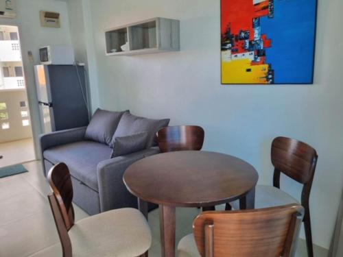 ein Wohnzimmer mit einem Sofa, einem Tisch und Stühlen in der Unterkunft Grandblue 311 in Mae Pim