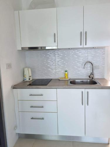 a kitchen with white cabinets and a sink at Grandblue 311 in Mae Pim