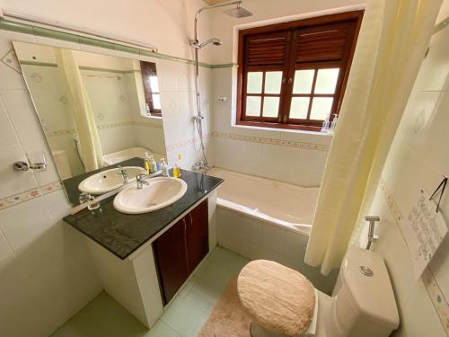 a bathroom with a sink and a toilet and a tub at Agasthi Airport Close in Katunayake